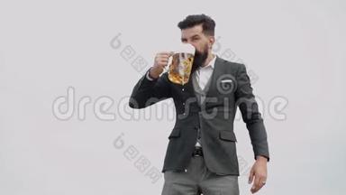 有趣的大胡子醉汉持有工艺啤酒。 优雅时尚的男人穿着古典服装，手里拿着啤酒的玻璃杯。
